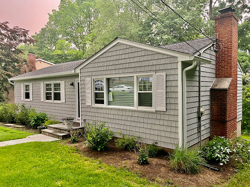 Beige house with newly installed roof, siding, windows, and gutters by Riga Home Pro in Easton, CT