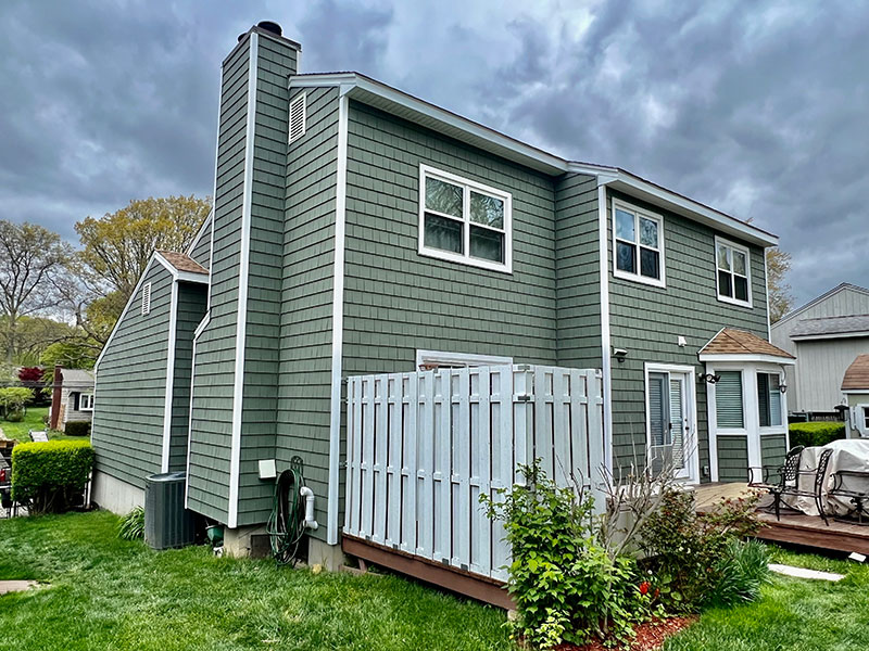 Stamford, CT residential house featuring new green siding and roofing by Riga Home Pro