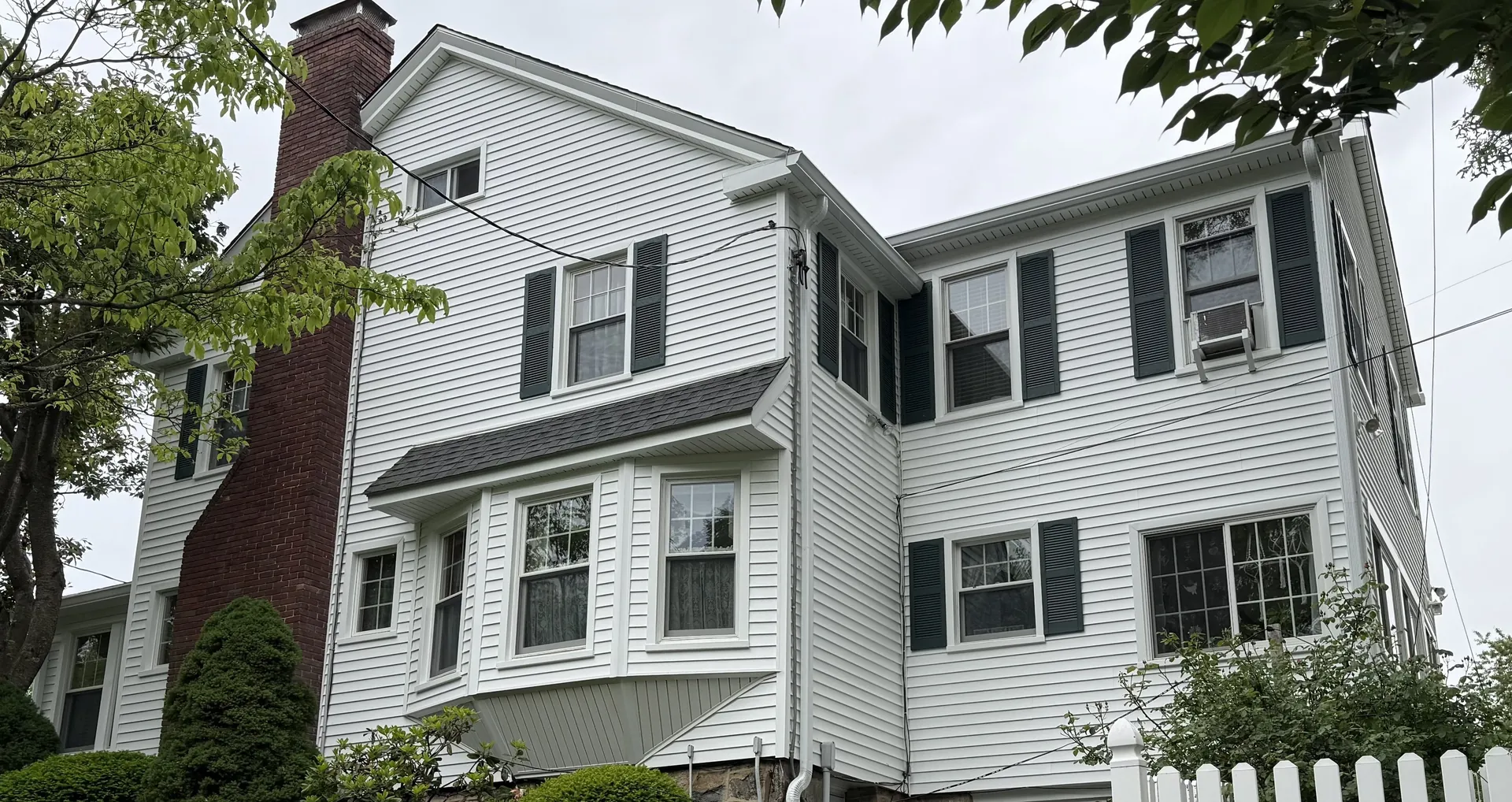 Roof replacement, siding, windows, and new gutters on a white home in Stamford, CT